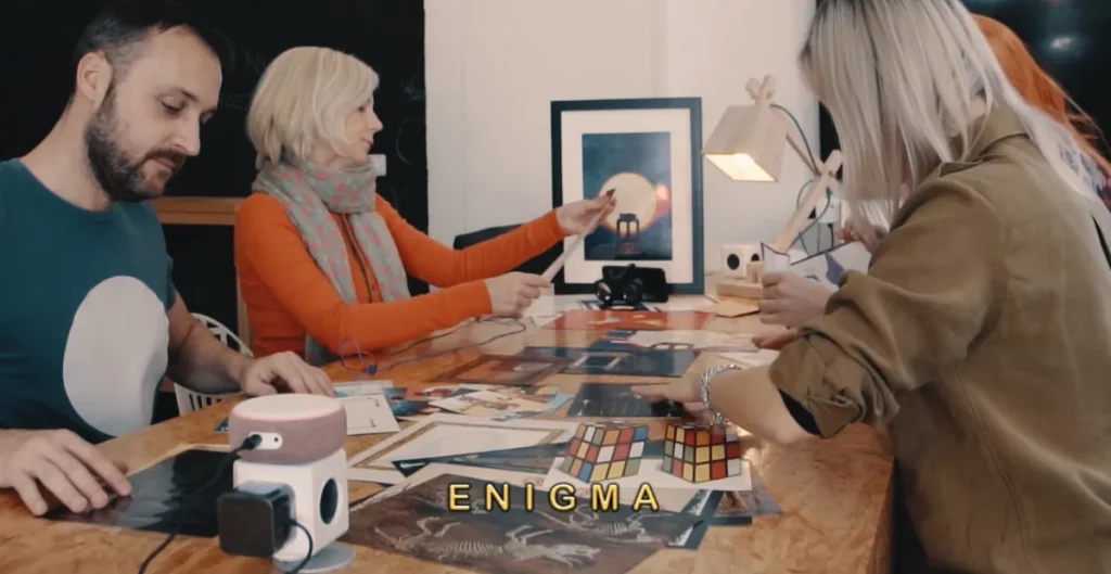 Actividades lúdicas para empleados en la mesa: compañeros de trabajo concentrados resolviendo pistas de un juego