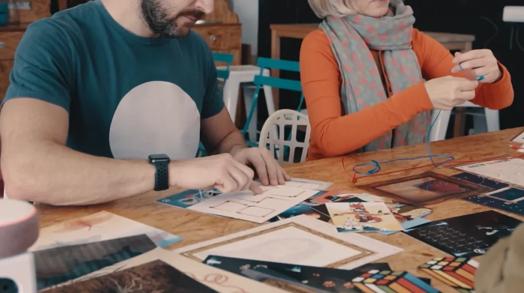 Dos compañeros resolviendo las pistas de un juego de mesa por equipos, una de las actividades lúdicas para empleados más sencillas