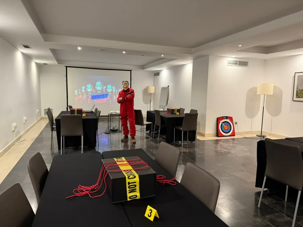 Sala de reuniones preparada para un escape room a domicilio, con el game master y las cajas de juego sobre la mesa