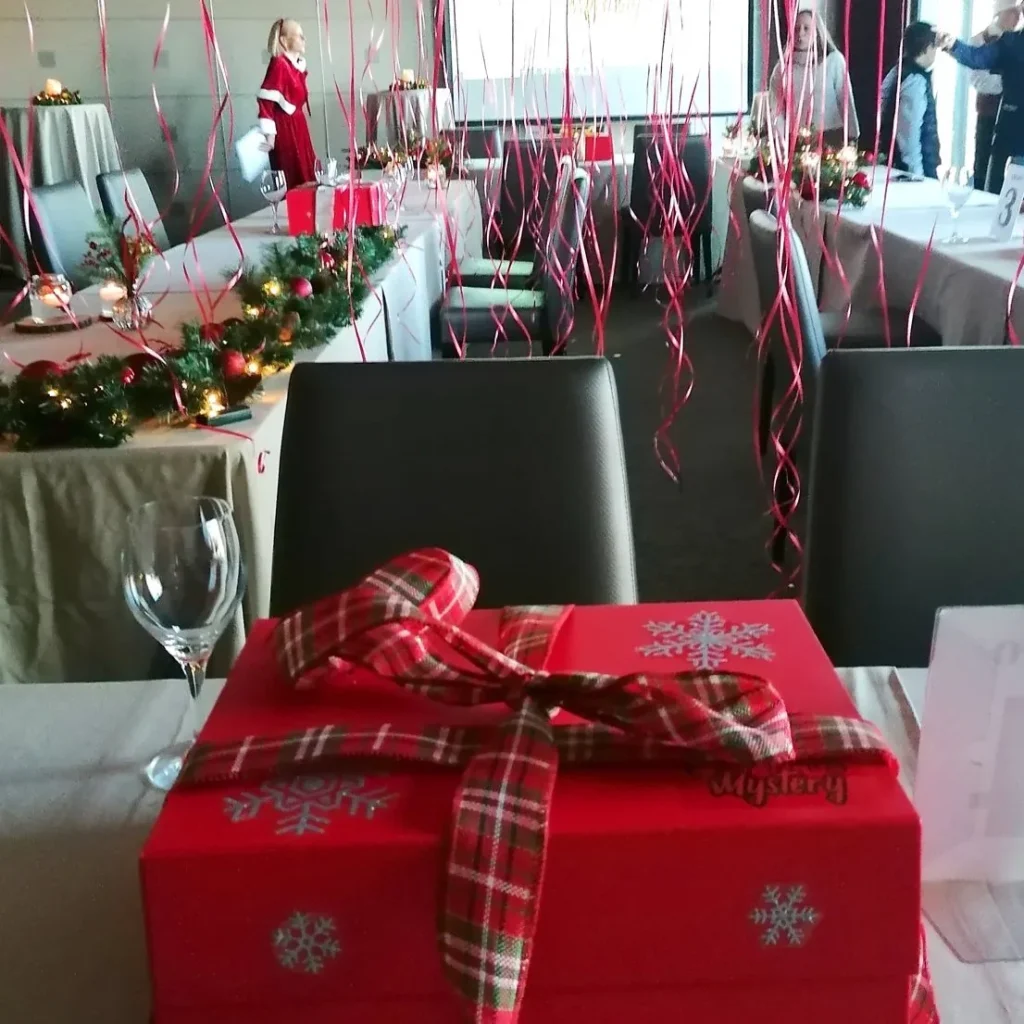 Caja de escape room de Navidad en la mesa de un restaurante decorado: actividades para fiestas de Navidad durante la cena de empresa