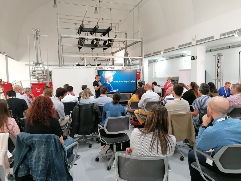Organizar eventos para empresas en Madrid: asistentes sentados frente a una pantalla durante una presentación